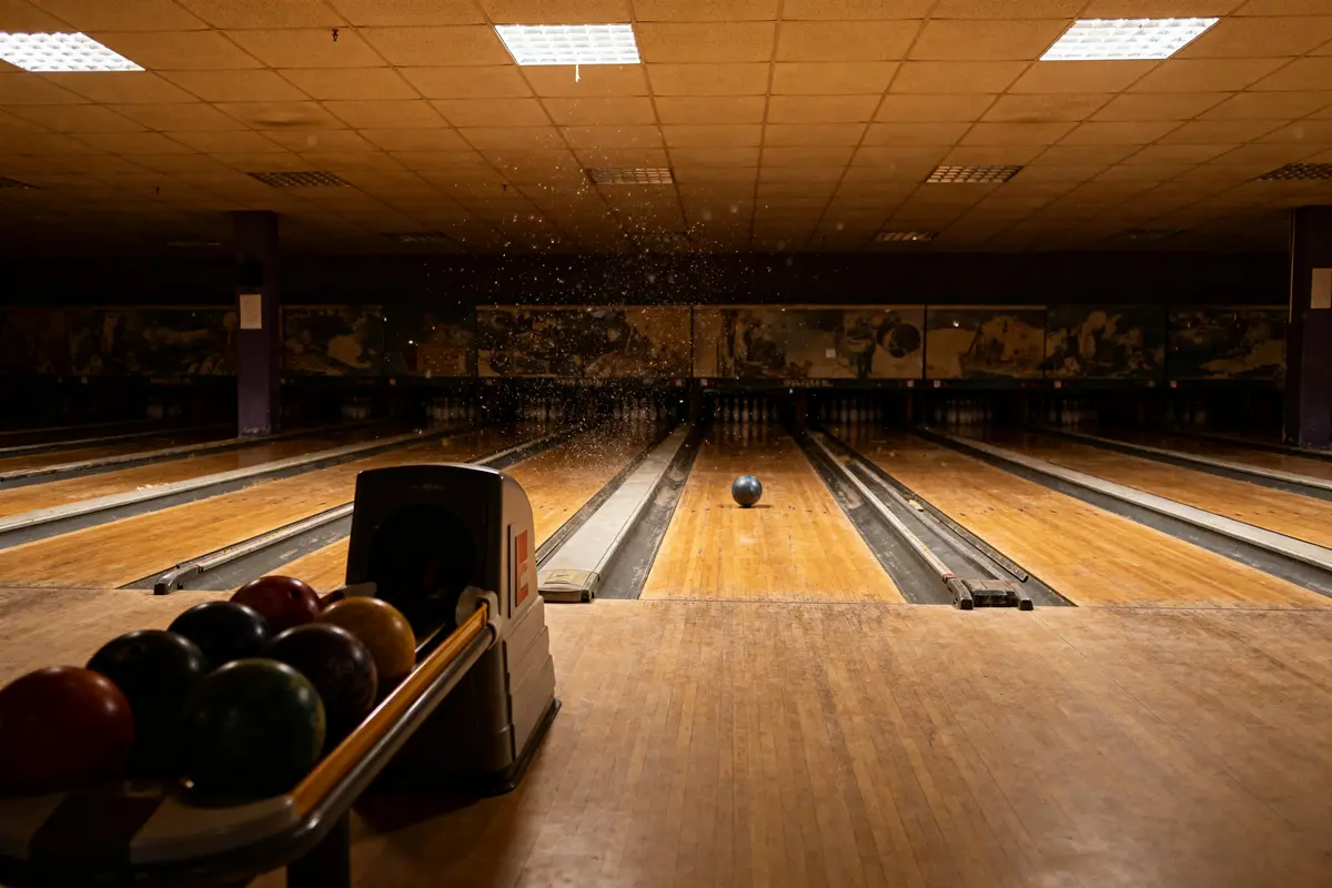 Piste de bowling au bowling de Champerret avec boule en mouvement et quilles au fond