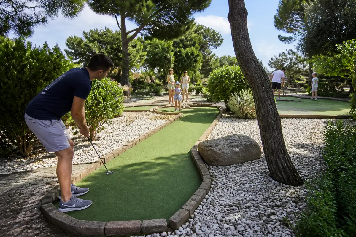 Homme jouant au mini golf à Toulon sur un parcours entouré de verdure
